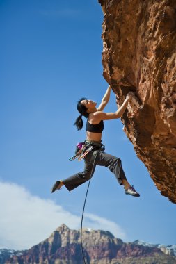 Rock climber clinging to a cliff. clipart