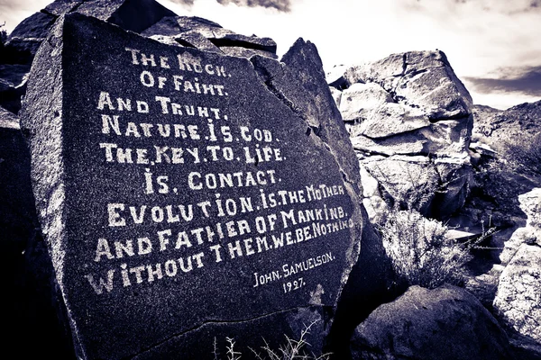 Stock image A proverb chiseled onto a rock in the desert.