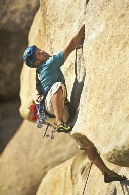 Climber clinging to a cliff. clipart