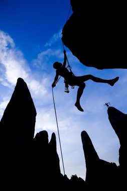 Climber dangling from a rope. clipart