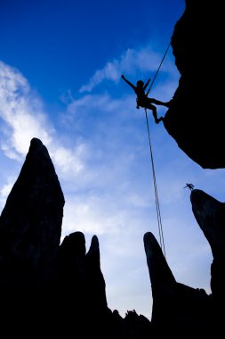 Rock climber rappelling. clipart