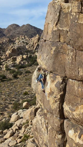 Femme grimpeuse accrochée à une falaise . — Photo