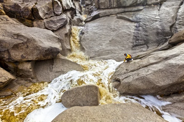 Wandelaar verkent een trapsgewijze waterval. — Stockfoto