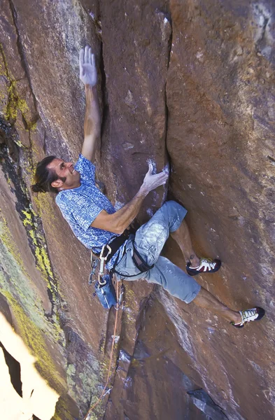 Klimmer klampt zich vast aan een klif. — Stockfoto