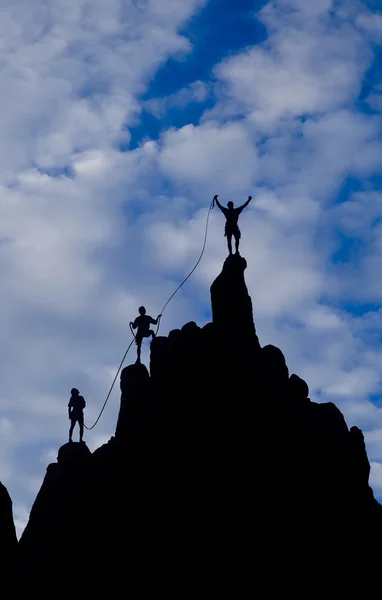 Team av klättrare som når toppen. — Stockfoto