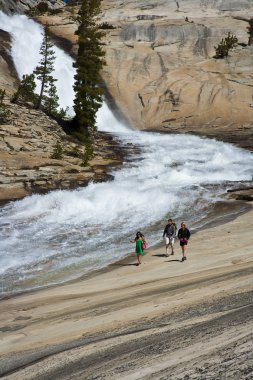 Hikers treking along cascades. clipart