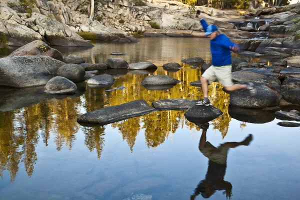 Turysta przekraczania rzeki. — Zdjęcie stockowe