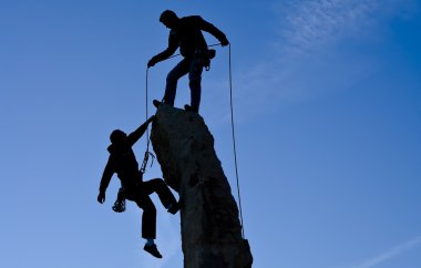 Team of climbers reaching the summit. clipart