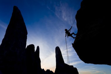 Rock climber rappelling. clipart