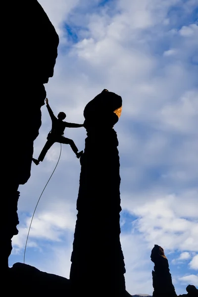 Rock climber reaching across a gap. — Stock Photo, Image