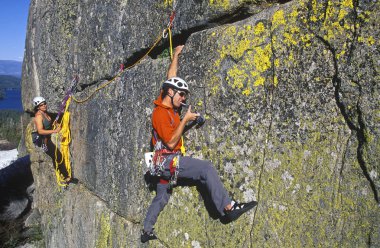 Team of climbers reaching the summit. clipart