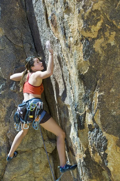 Bir uçurum için sıkı bir kadın dağcı. — Stok fotoğraf