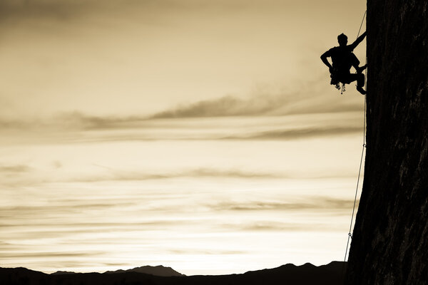 Rock climber clinging to a cliff.