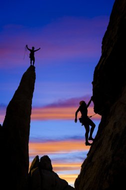 Team of rock climbers reaching the summit. clipart