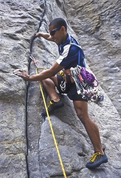 Escalador de rocas aferrado a un acantilado . — Foto de Stock
