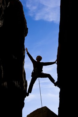 Rock climber reaching. clipart