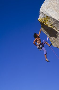 Climber clinging to a cliff. clipart