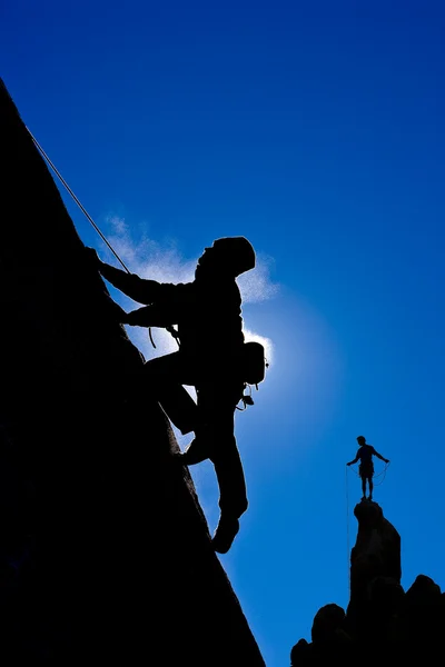 Bergsteiger in der Silhouette. — Stockfoto