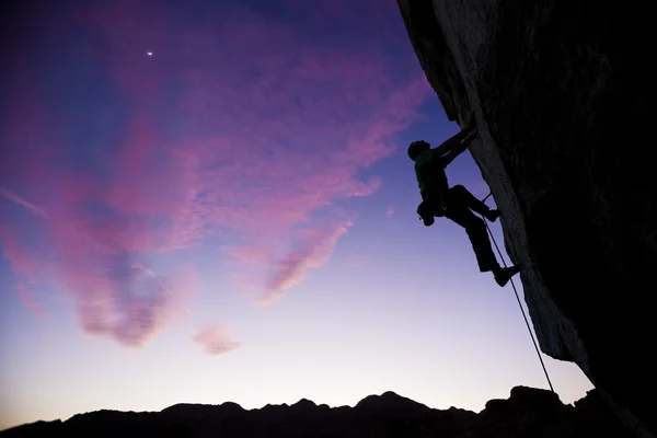 Rock klimmer klampt zich vast aan een overstek. — Stockfoto