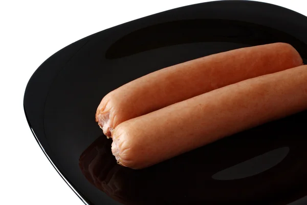 Sausage on a black platter — Stock Photo, Image