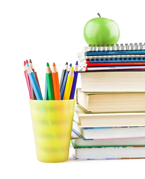 Livros didáticos e cadernos ao lado dos lápis e maçã verde no topo — Fotografia de Stock