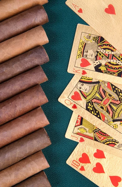 Zigarren und Spielkarten auf grünem Baiser.. — Stockfoto