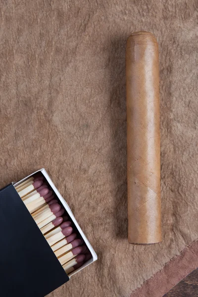 Stock image Cigar and matches on a brown background