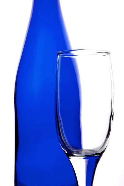 Прозора скляна пляшка на синьому фоні — стокове фото