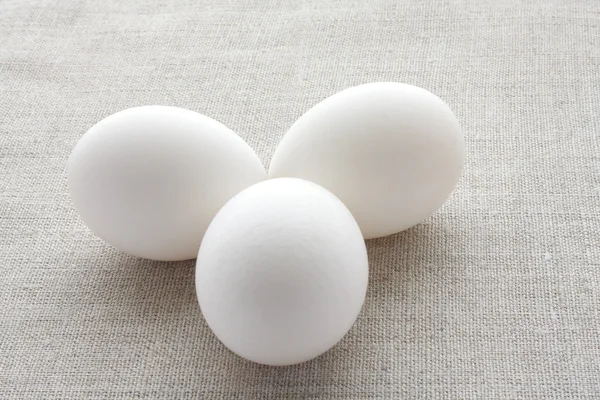 stock image Three fresh chicken egg white on the fabric