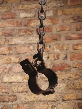 Old shackles against a brick wall clipart