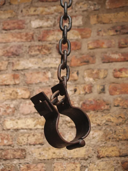 Old shackles against a brick wall — Stock Photo, Image