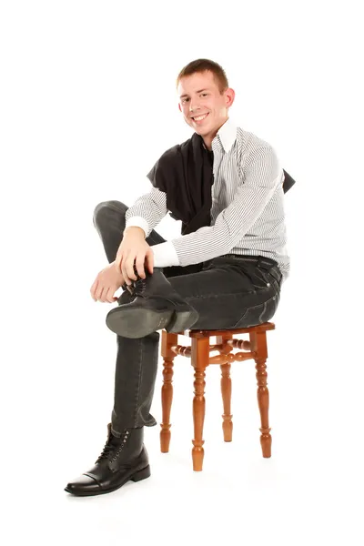 Homem contra sentado em uma cadeira e sorrindo — Fotografia de Stock