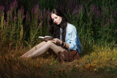 The woman reads the book on the nature clipart