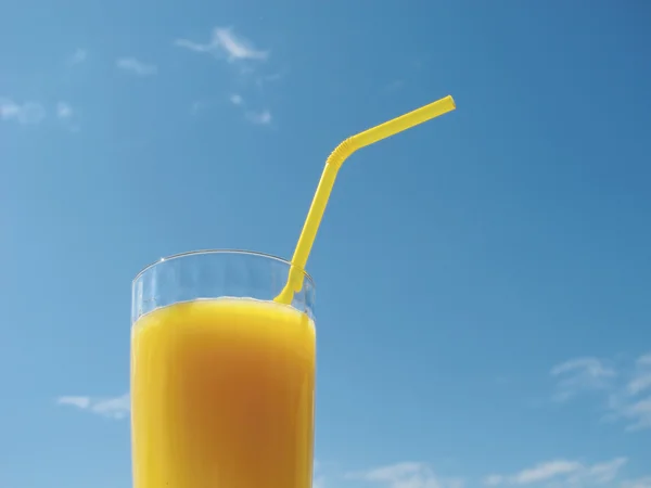 stock image Orange juice in glass. Blue sky.