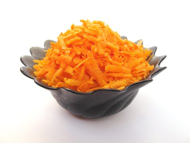 Grated orange carrot in a black plate clipart