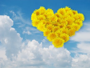 Heart from yellow flowers. Blue sky. clipart