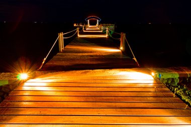 Wooden jetty in night scene clipart