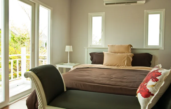 Dormitorio blanco con cama de sábana marrón y sofá de pie —  Fotos de Stock