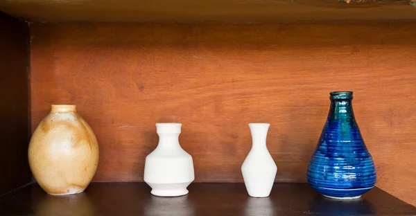 Four earthenwares on wooden shelf — Stock Photo, Image
