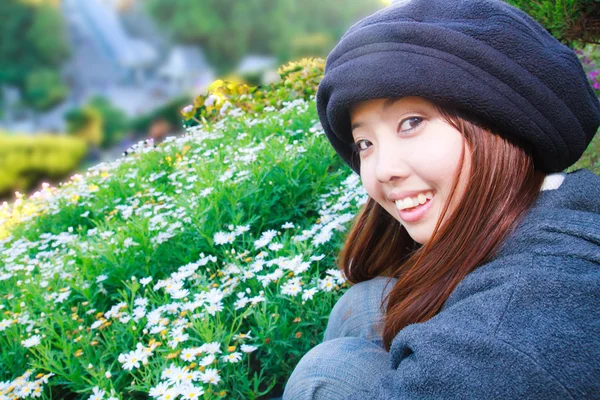 Jonge vrouw is glimlachend voor tuin — Stockfoto