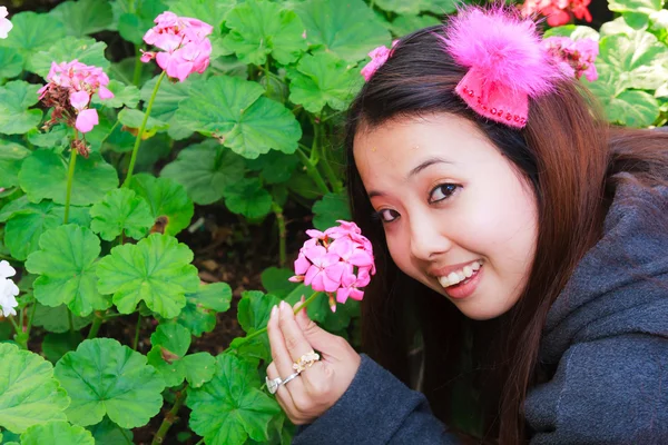 Jovem mulher colhendo flores e sorrir — Fotografia de Stock