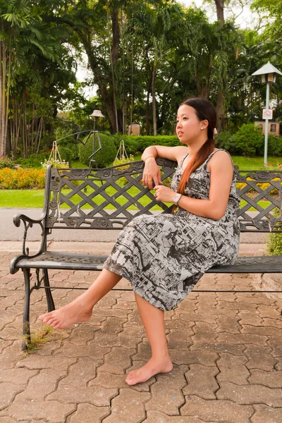 stock image Asian women distracted on bench in park