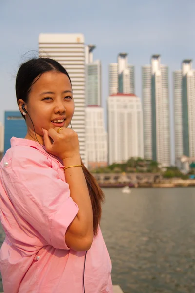 Молодые азиатки отдыхают со строительством на заднем плане — стоковое фото