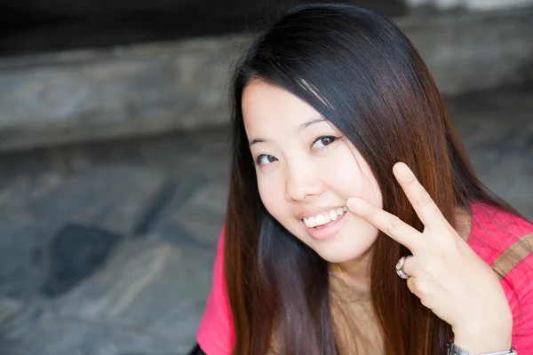 2 本の指を示すアジア女性 — ストック写真