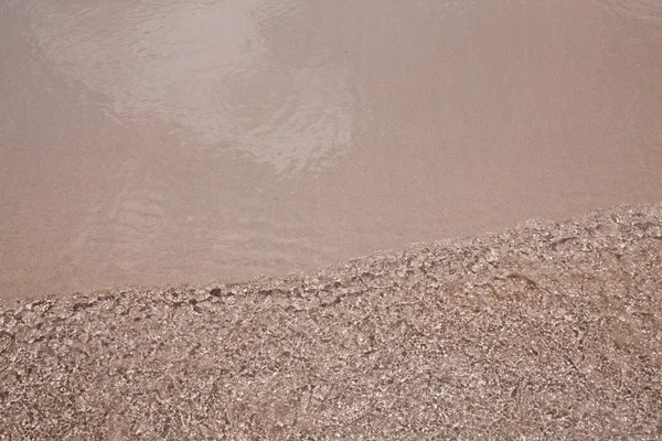 Kum plaj arka plan doku su dalgalanma — Stok fotoğraf
