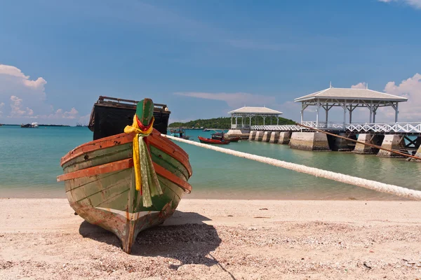Träbåt på stranden med träbro — Stockfoto