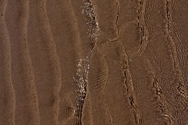 Tekstura tło koryta wody marszczyć morze pasiasty piasek — Zdjęcie stockowe