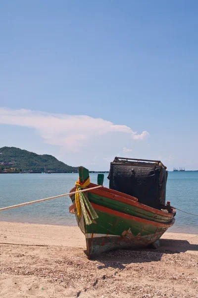 Drewnianą łodzią na plaży z niebieski niebo od strony pionowe — Zdjęcie stockowe