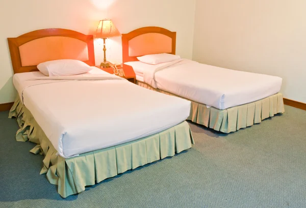 Двуспальная белая кровать с лампой — стоковое фото