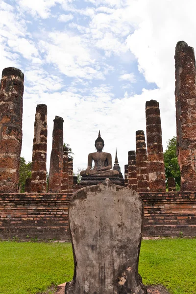 Статуя Будды среди колонн в вертикальном положении — стоковое фото